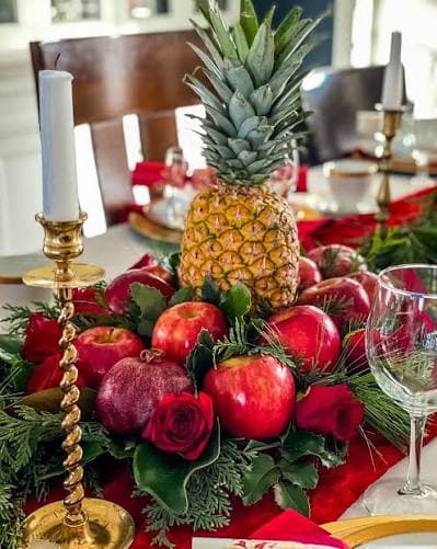 a table with a pineapple and other fruit at the center of the table.